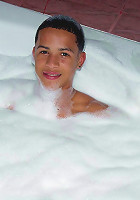 Latino boy having bubble bath in cozy tub